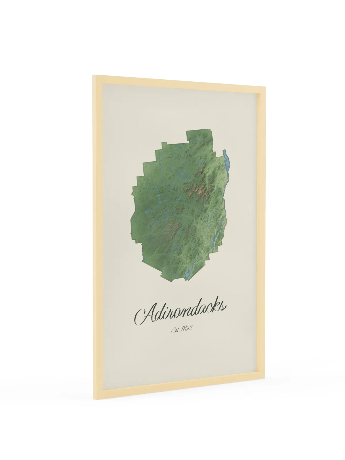 Adirondack Park Map as a 24 by 36 inch framed print in a natural wood frame: a painted-style map of the Adirondack Park with its lakes, rivers and High Peaks in green on cream paper, with Adirondacks, Est. 1892 in dark green script below.