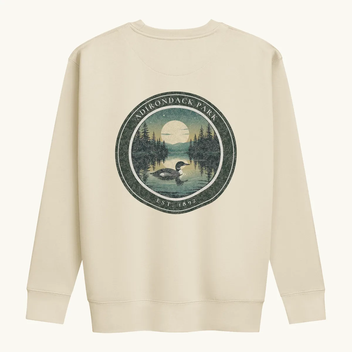 Loon at Night Crewneck in Bone, back: a loon on a moonlit Adirondack lake in a round badge, Adirondack Park, Est. 1892.