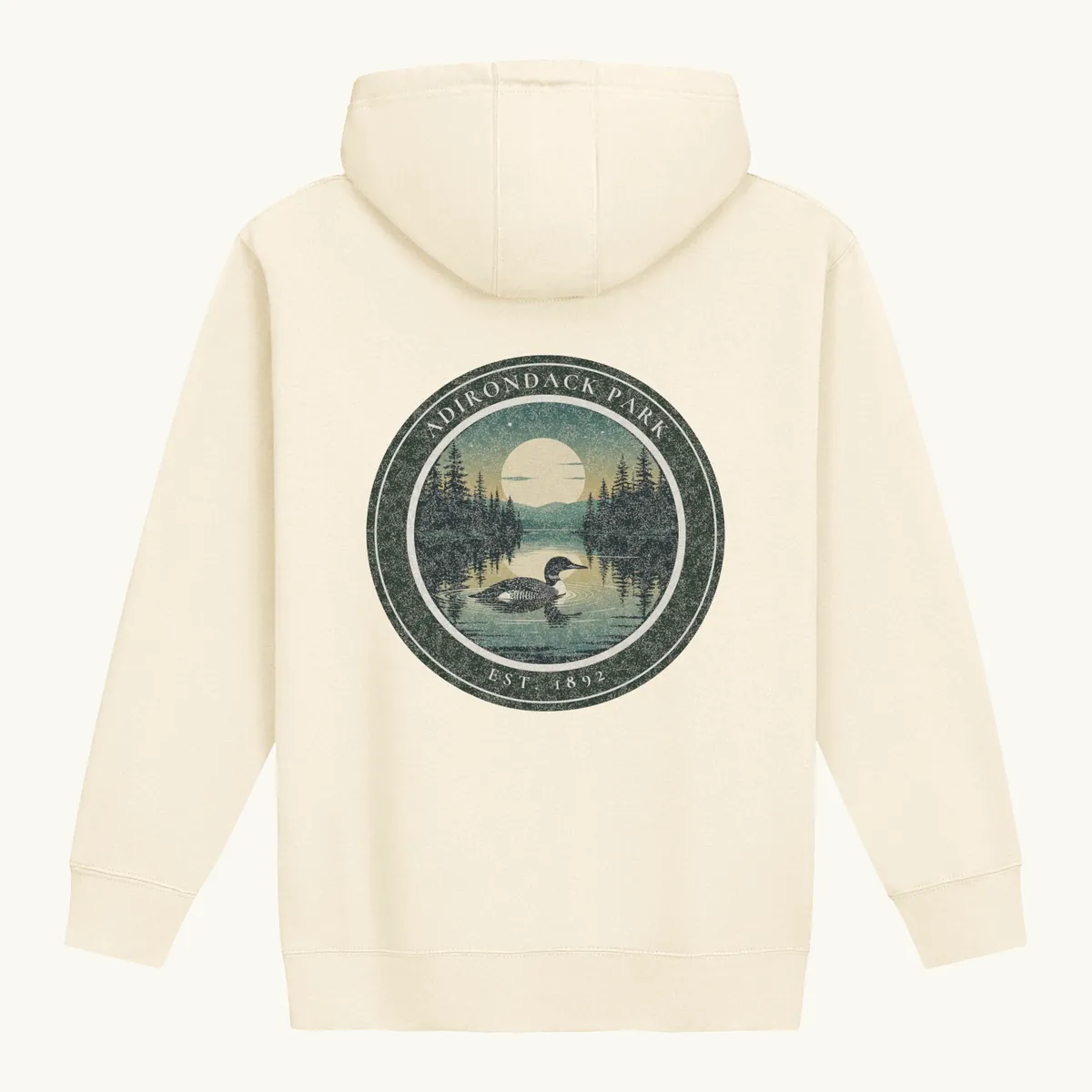 Loon at Night Hoodie in Bone, back: a loon on a moonlit Adirondack lake in a round badge, Adirondack Park, Est. 1892.