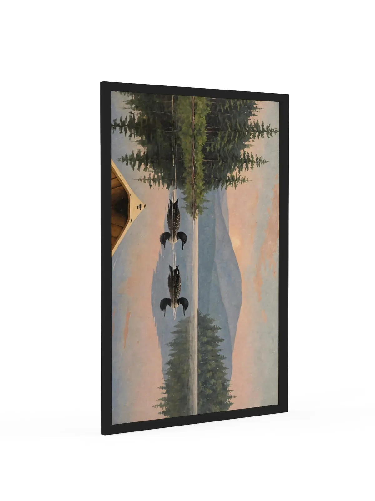 Loon Pair at Sunrise as a 24 by 36 inch framed print in a black frame: two common loons swimming side by side across a still Adirondack lake at sunrise, seen from the bow of a wooden canoe, with spruce shores, a blue mountain and a peach-pink sky doubled in the water, in soft, traditional oil brushwork.