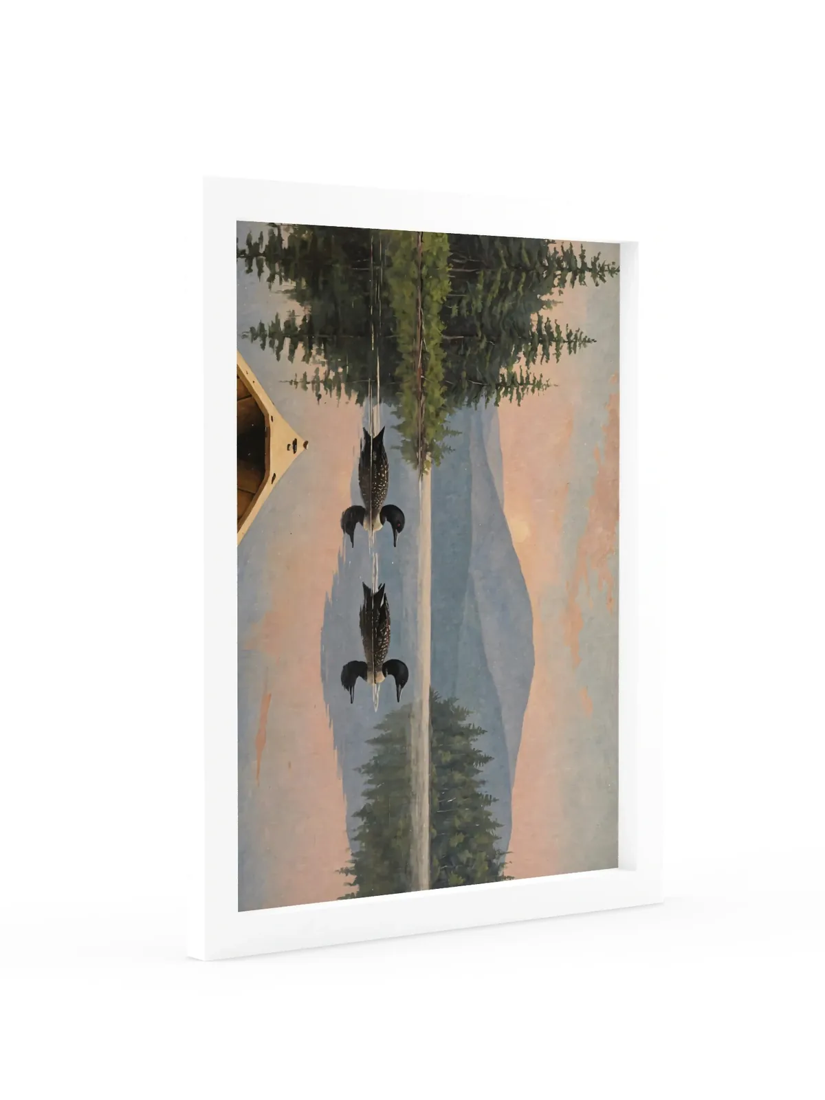 Loon Pair at Sunrise as a 12 by 16 inch framed print in a white frame: two common loons swimming side by side across a still Adirondack lake at sunrise, seen from the bow of a wooden canoe, with spruce shores, a blue mountain and a peach-pink sky doubled in the water, in soft, traditional oil brushwork.