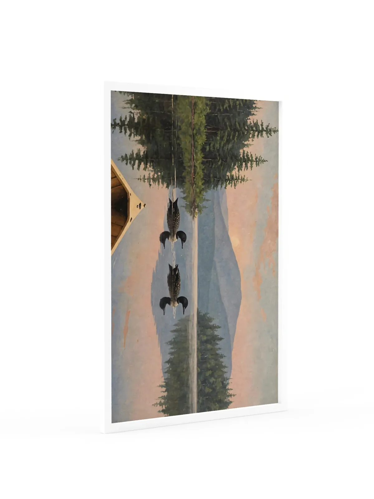 Loon Pair at Sunrise as a 24 by 36 inch framed print in a white frame: two common loons swimming side by side across a still Adirondack lake at sunrise, seen from the bow of a wooden canoe, with spruce shores, a blue mountain and a peach-pink sky doubled in the water, in soft, traditional oil brushwork.